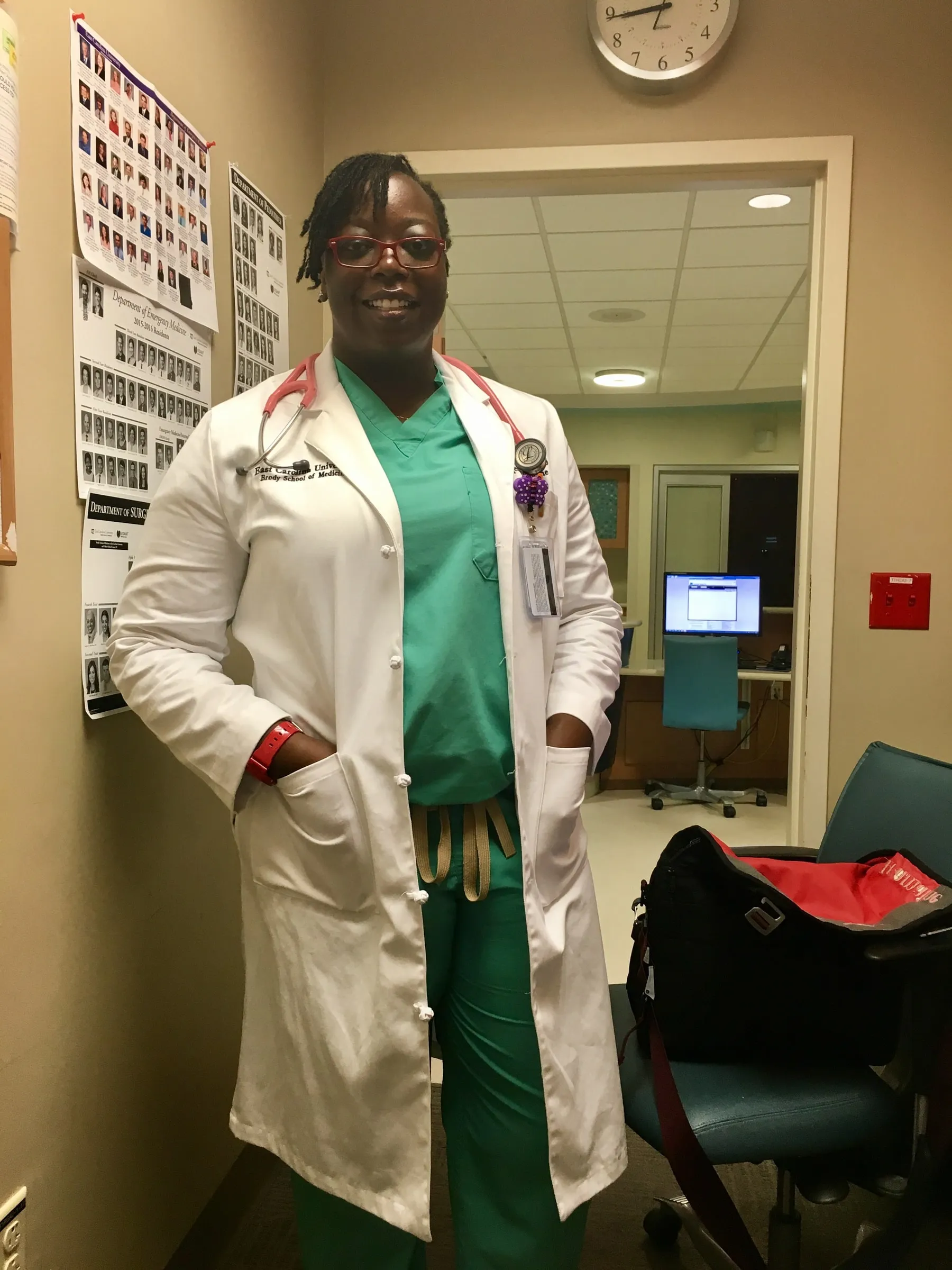 Dr. Tramaine Wilkinson in her white coat and scrubs during her emergency medicine residency
